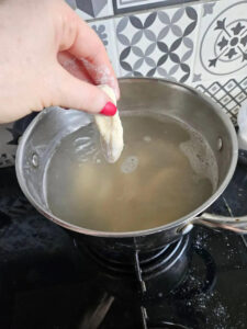 Leniwe pierogi w dużym garnku z wrzącą, gorącą wodą.