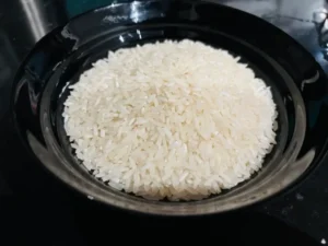 Plain rice. Photo of rice on a black table and in a black plate. Is Rice Gluten-Free?
