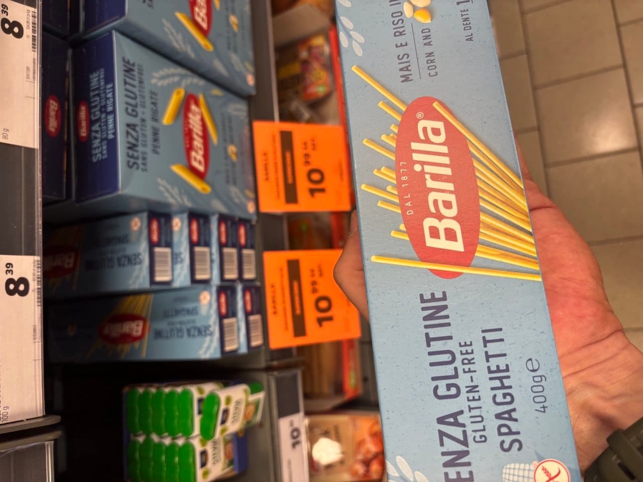 Jasnoniebieskie opakowanie makaronu Barilla Senza Glutine Spaghetti o wadze 400 g na tle półki sklepowej z widocznymi cenówkami. Produkty bezglutenowe w Netto.