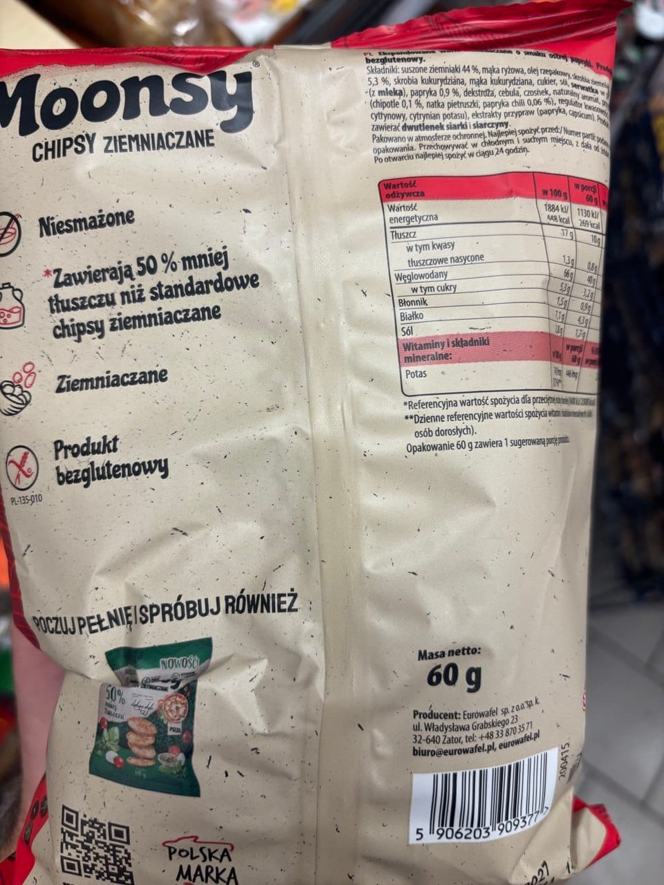 Tył opakowania chipsów ziemniaczanych Moonsy o smaku ostrej papryki o wadze netto 60 g, z widoczną tabelą wartości odżywczych, składem produktu, znakiem Produkt bezglutenowy oraz kodem kreskowym. Produkty bezglutenowe w Netto.