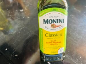 Butelka oliwy Monini Classico Extra Vergine jako dodatek do obiadu bezglutenowego