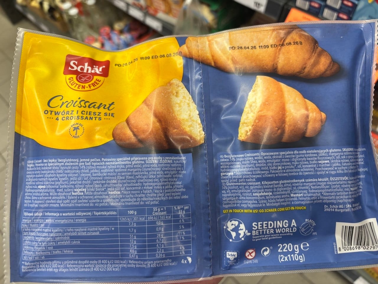 Tył opakowania bezglutenowych rogalików Schär Croissant z tabelą wartości odżywczych, wielojęzycznym składem, kodem kreskowym oraz wagą netto 220 g. Produkty bezglutenowe w Netto.