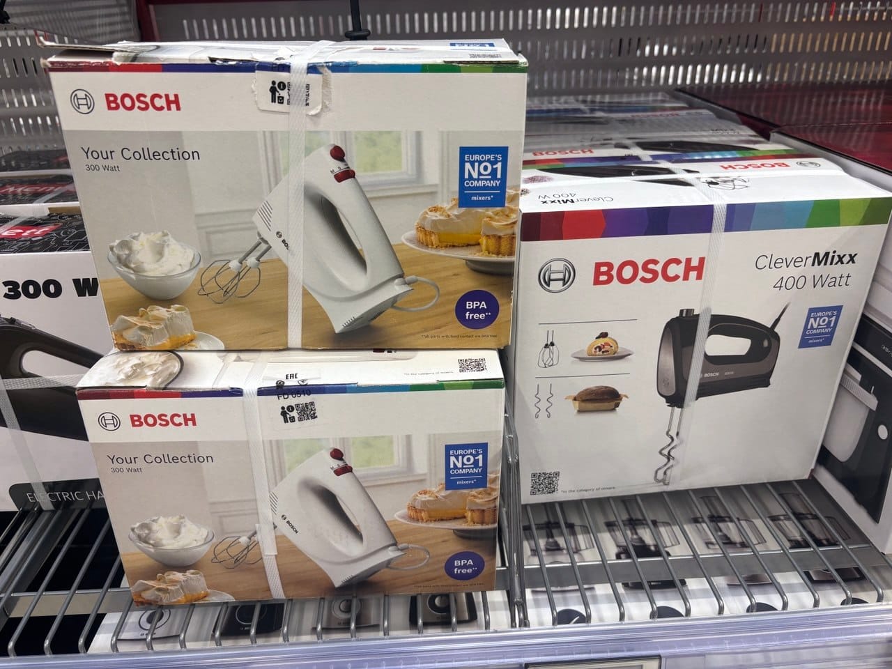 Pudełka z blenderami ręcznymi i mikserami marki Bosch na sklepowej półce, przydatnymi w kuchni roślinnej i bezglutenowej.
