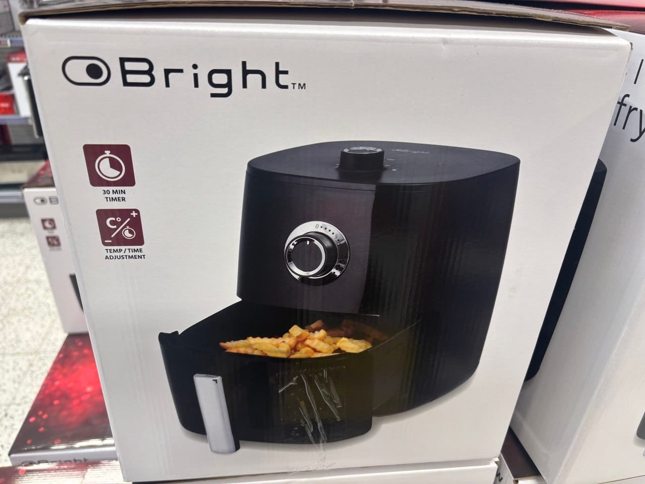 Pudełko z czarną frytkownicą beztłuszczową marki Bright na półce sklepowej.