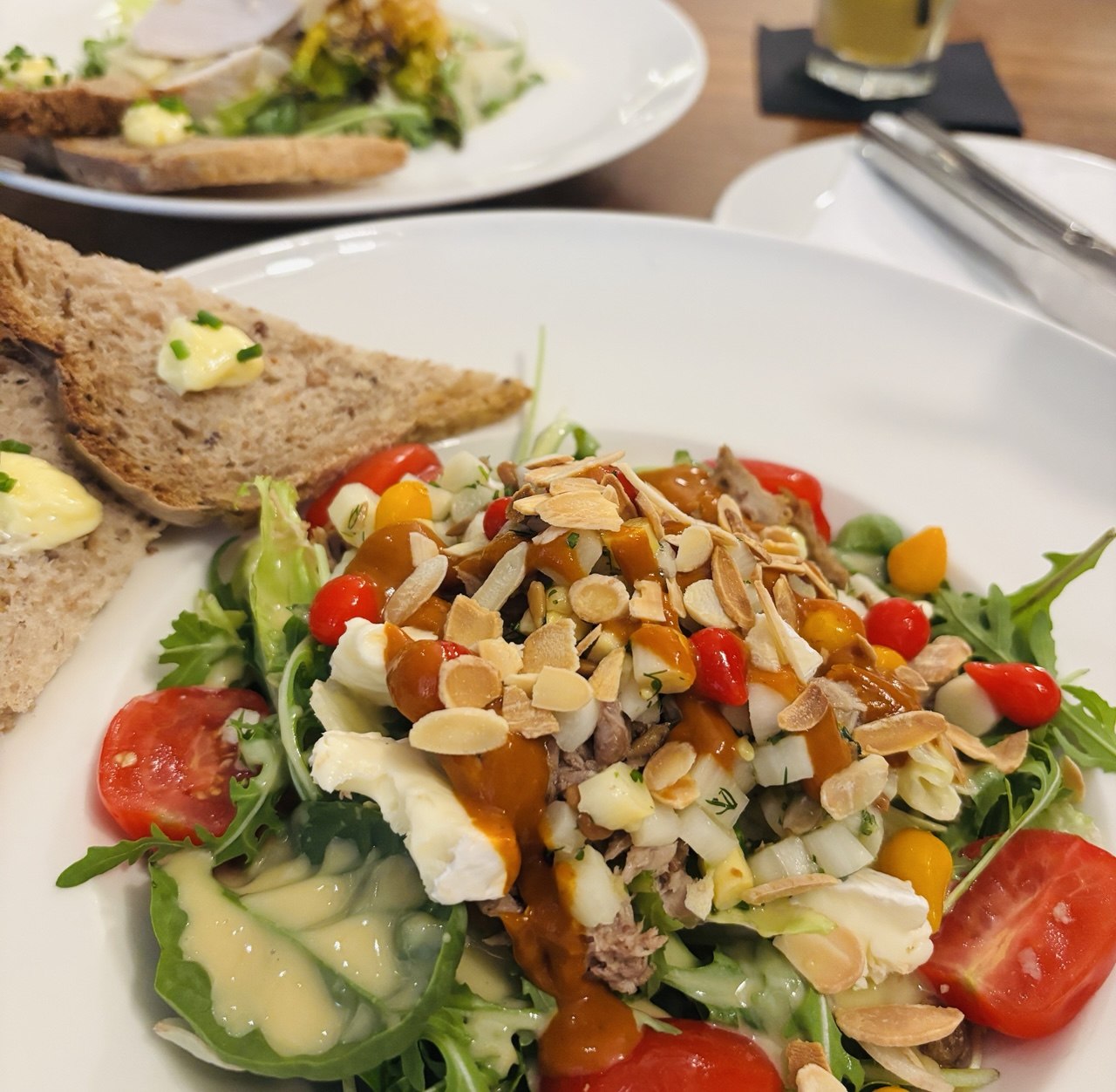 Fresh vegetarian salad with almonds and safe gluten-free bread at a certified restaurant in Madrid