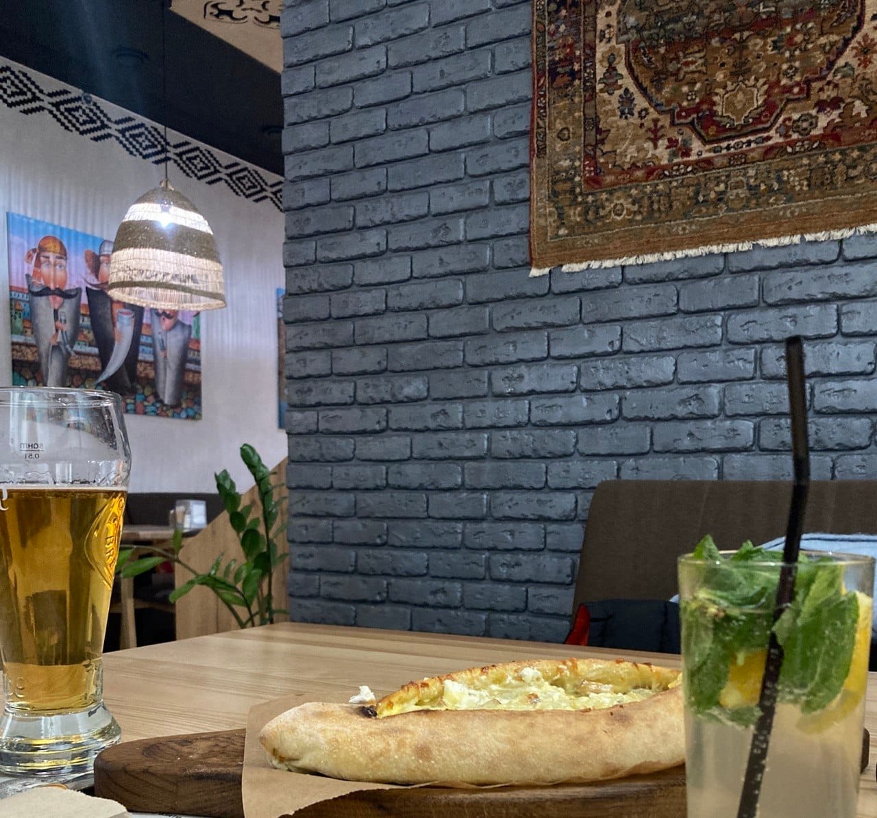 Traditional Adjarian khachapuri with cheese and egg, served on a wooden board in a Georgian restaurant.