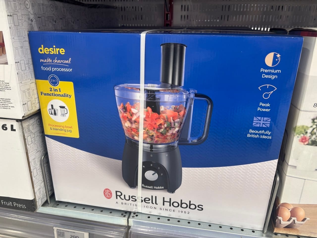 Pudełko robota wielofunkcyjnego Russell Hobbs Desire Matte Charcoal na sklepowej półce, przydatnego w kuchni roślinnej i bezglutenowej.