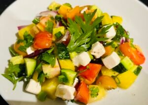 Zbliżenie na sałatkę z pepino, fizalisem, pomidorami i wegańską fetą