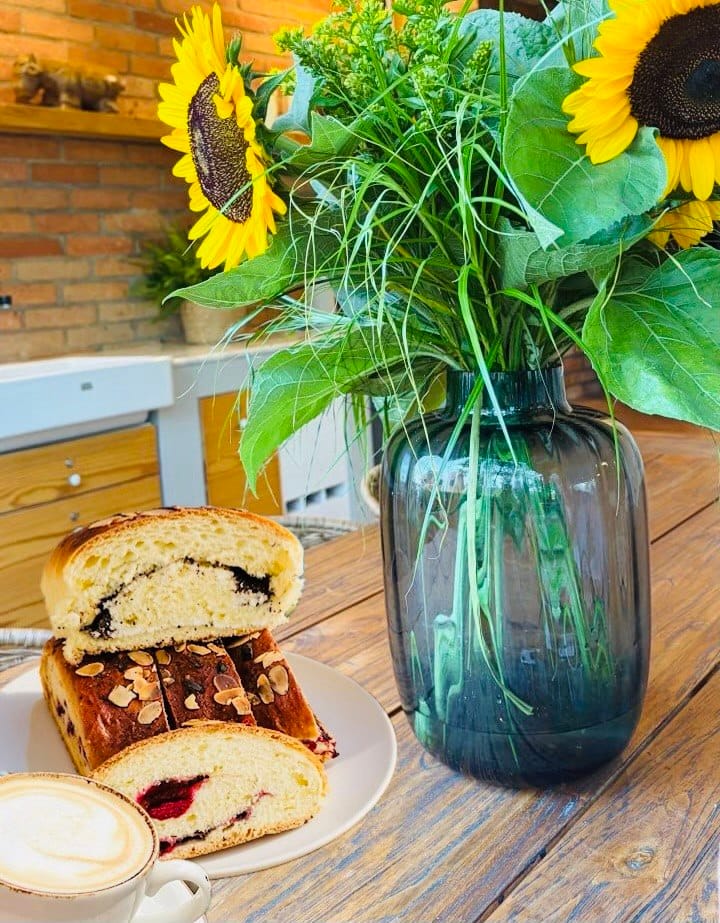Gluten-free sweet bread with poppy seeds and fruit filling served with coffee at a bakery in Prague.