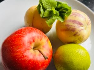 Składniki na napój z pepino, jabłka i limonki: dwa owoce pepino, czerwone jabłko, limonka i świeża mięta