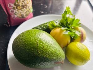 Składniki na sałatkę z awokado i pepino: awokado, ogórek, pepino, limonka, natka pietruszki i mieszanka pestek