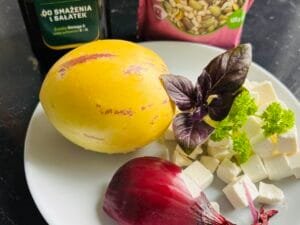 Składniki na sałatkę z pepino — owoc pepino, wegańska feta, czerwona cebula, oliwa, pestki dyni i słonecznika