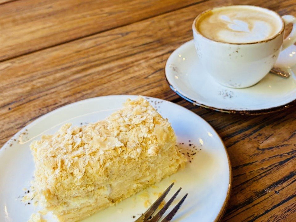 Filiżanka cappuccino i bezglutenowe ciasto na drewnianym stole.